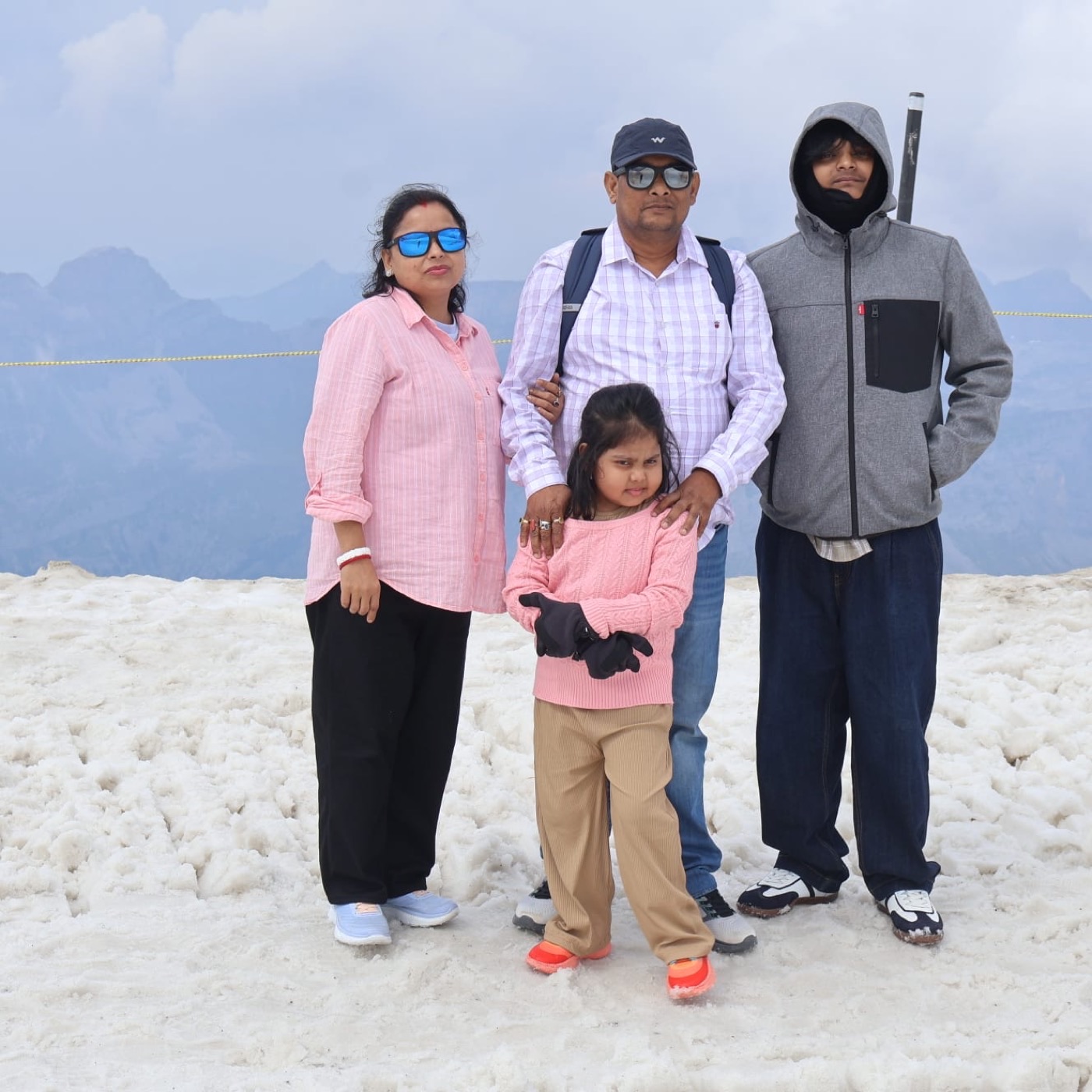 A family on the snow at an alpine summit