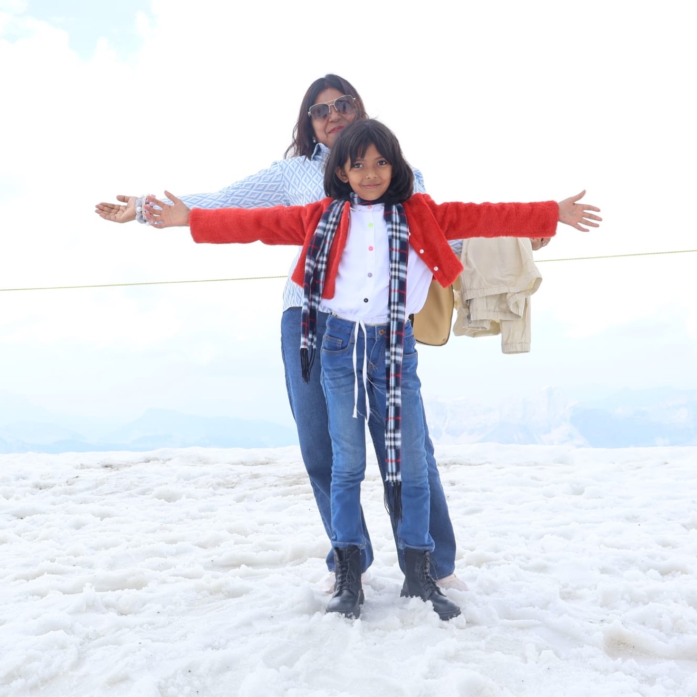 A grandmother and granddaughter on the snow at an alpine summit
