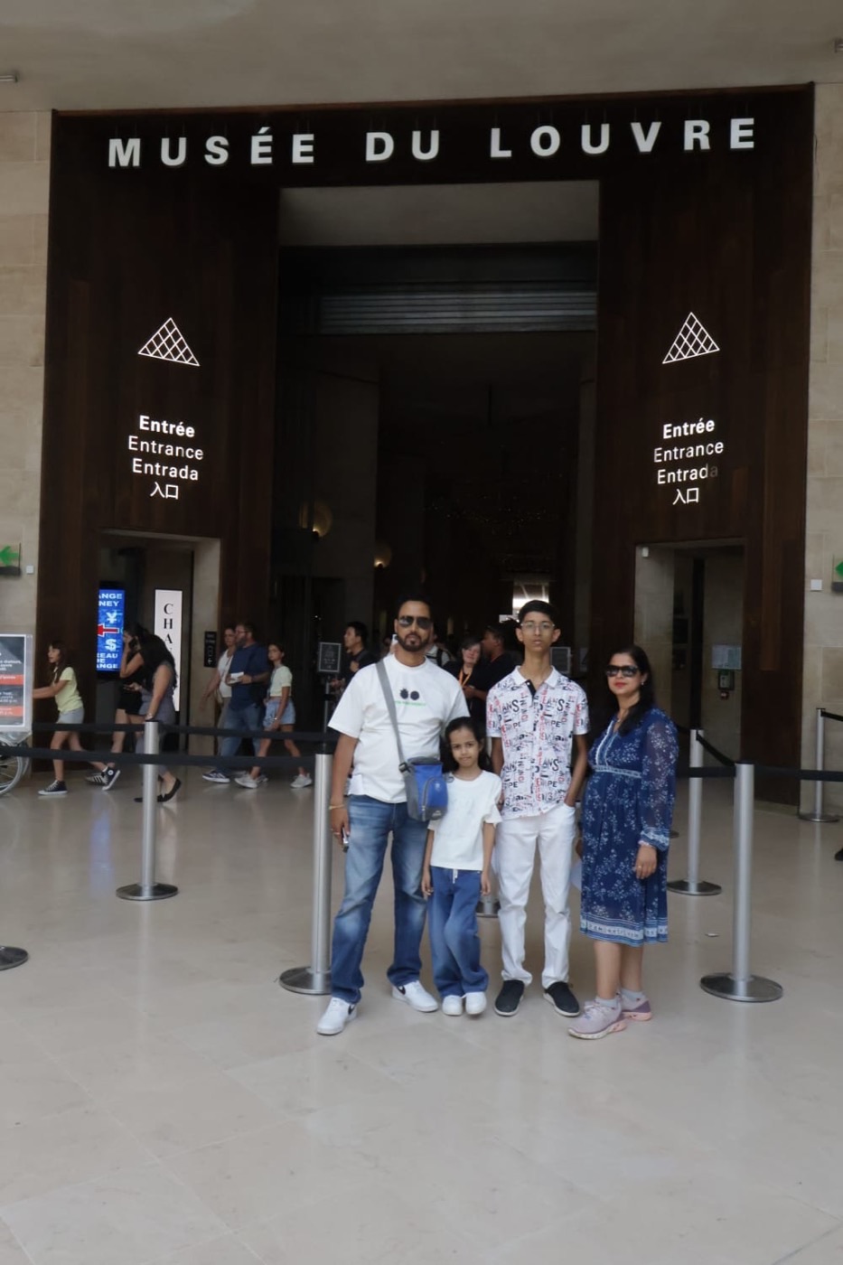 A family of four at the entrance to the Musée du Louvre, Paris